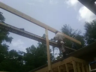Carpenter setting a ridge beam over a new addition frame — Ice Dam Removal by Roofing Brothers in Mc Veytown