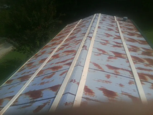 Rusted metal roof panels with new wood purlins before replacement — Storm Damage Roof Repair in Mc Veytown by Roofing Brothers