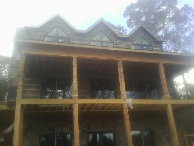 Dormers and porch framing on a large log home under construction — Roof Coating work by our crew in Mc Veytown