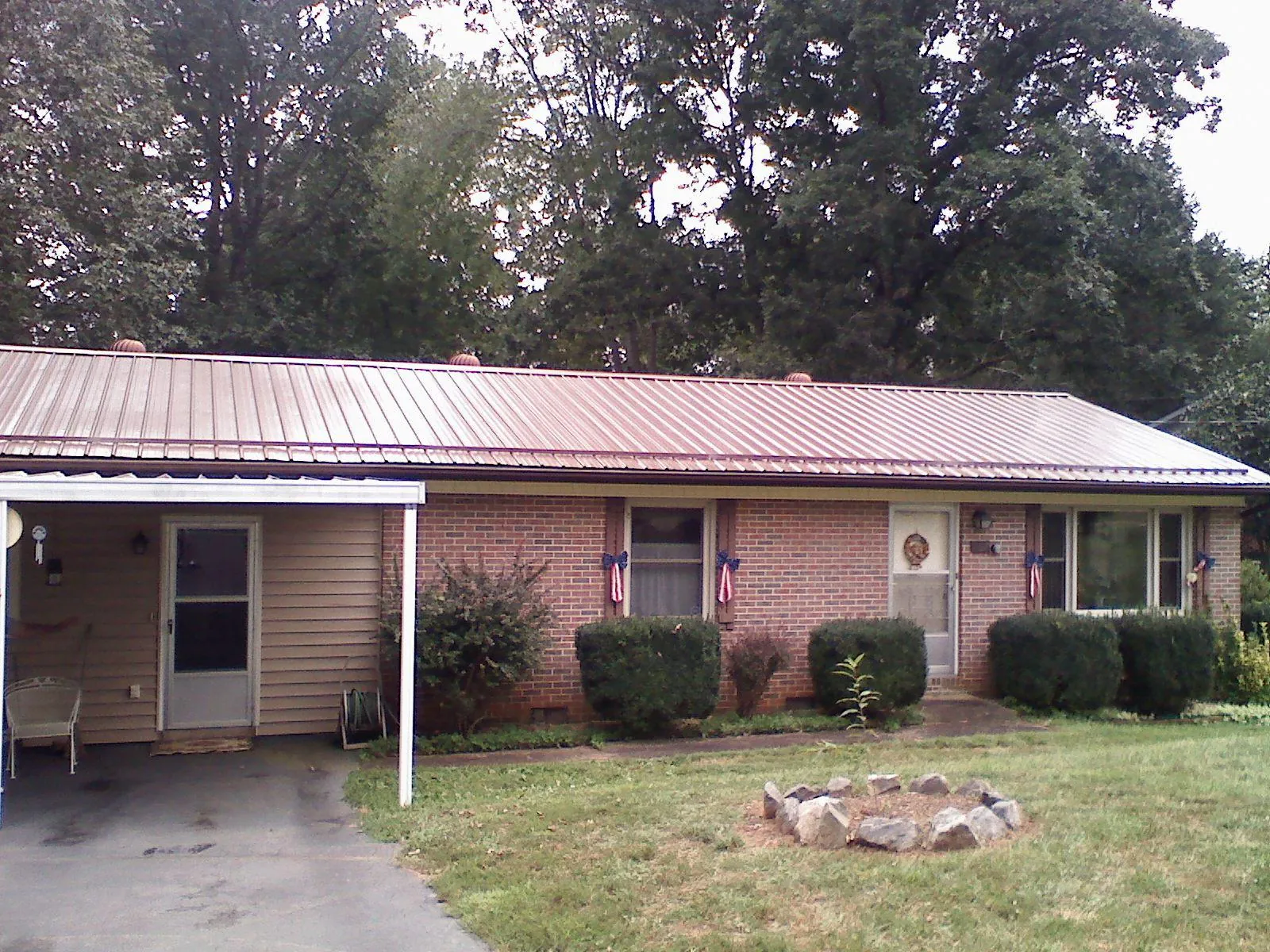 Bronze metal roof and carport on a brick ranch home — Roof Repair work by our crew in Mc Veytown